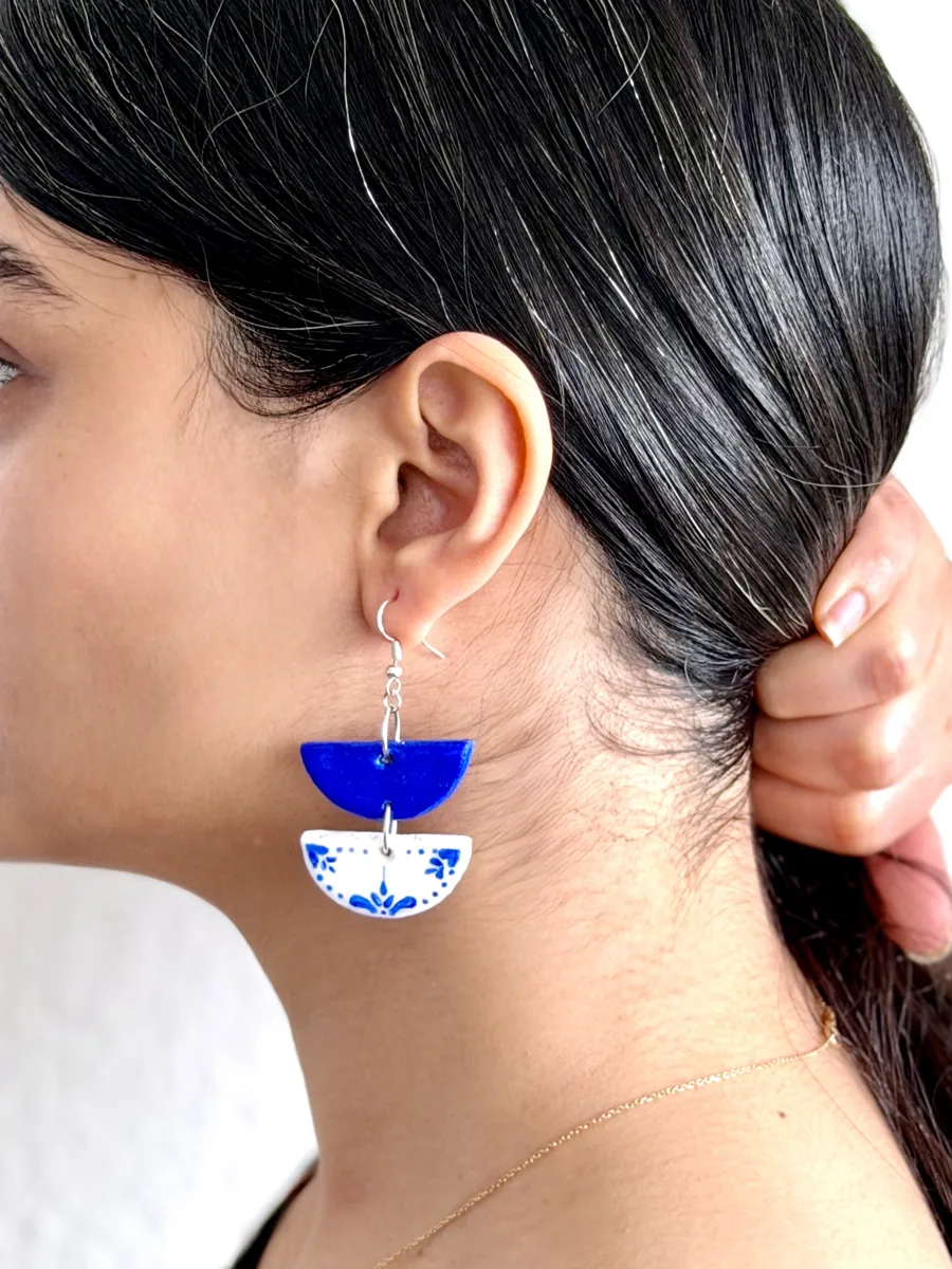 Blue and white earring worn on the ear